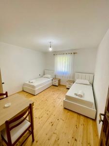 two beds in a room with a wooden floor at Mountain Oasis in Valbonë