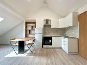 cocina con armarios blancos y mesa de madera en Twins Apartments, en Zagreb