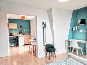 a room with a table and chairs and a kitchen at Palais du Luxembourg in Roubaix