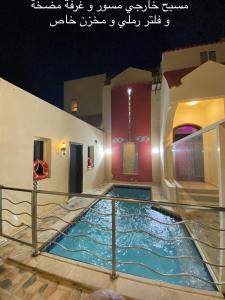 einen Pool in einer Villa in der Nacht in der Unterkunft Al Ahlam Island Villa Durrat AlArous فيلا جزيرة الأحلام درة العروس in Durrat Al-Arus