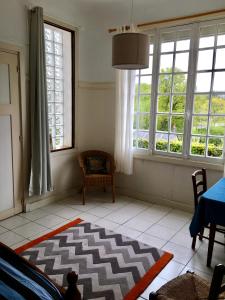 sala de estar con 2 ventanas y alfombra en Villa des Millepertuis, en Bagnoles de l'Orne