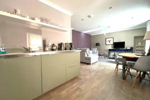 a kitchen and a living room with a table at Thistle Apartment in Golspie