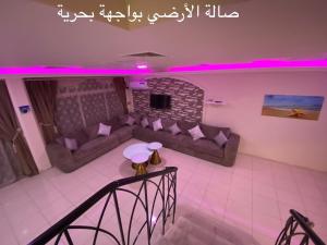 ein Wohnzimmer mit einem Sofa und einem Kamin in der Unterkunft Al Ahlam Island Villa Durrat AlArous فيلا جزيرة الأحلام درة العروس in Durrat Al-Arus