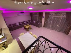 einen Blick über ein Wohnzimmer mit lilafarbener Beleuchtung in der Unterkunft Al Ahlam Island Villa Durrat AlArous فيلا جزيرة الأحلام درة العروس in Durrat Al-Arus
