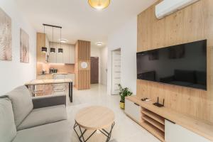 a living room and kitchen with a couch and a table at Apartament Eco Modern III by HolidaySun in Sianozety