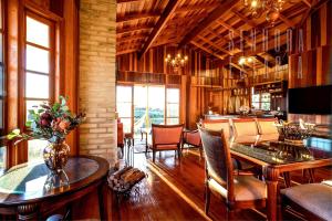 a living room with tables and chairs and a dining room at Casa Araguaia Rural Pôr-do-sol. Casa de Campo #18 in Florianópolis