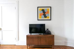 a flat screen tv sitting on a wooden stand in a room at Garden Guest Suite in Brooklyn