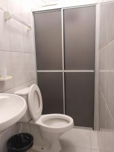 a bathroom with a shower with a toilet and a sink at Hotel e Pousada Mape Ltda in Guanamby