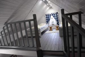 格但斯克新莊園的住宿－Domek pod wierzbami，一间设有床铺的房间,一间房子里设有楼梯