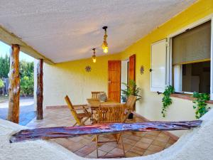 una casa con patio con mesa de madera y sillas en La Parapepita - Villetta con giardino privato, en Orosei