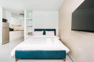um quarto com uma cama grande e uma televisão de ecrã plano em Snug studio apartment with shared garden II em Atenas