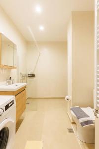 ein weißes Bad mit einer Waschmaschine in der Unterkunft Snug studio apartment with shared garden II in Athen