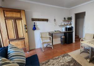 a living room with a kitchen with a table and a door at Little Greece in Cape Town