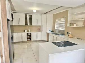 a large kitchen with white cabinets and a counter top at Coral Bliss in Walvis Bay