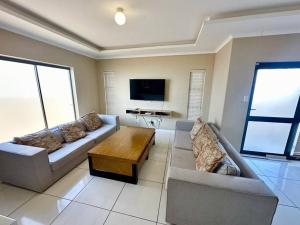 a living room with a couch and a coffee table at Coral Bliss in Walvis Bay