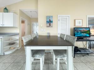 une cuisine avec une table et des chaises ainsi qu'une télévision dans l'établissement Seascapes - W153 home, à Wells