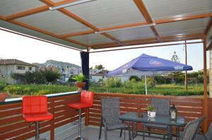 a patio with a table and chairs and an umbrella at 3SYS in Zakynthos