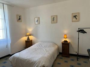- une chambre avec un lit blanc et deux lampes dans l'établissement Petite maison et son jardinet, à Angers
