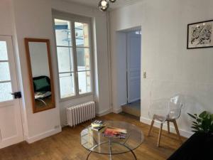 - un salon avec une table en verre et une fenêtre dans l'établissement Petite maison et son jardinet, à Angers