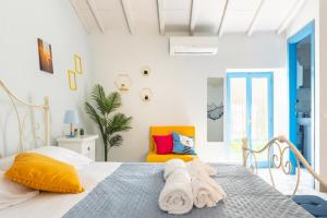 - une chambre blanche avec un lit et une chaise orange dans l'établissement La Casa del Pescatore - Lake Trasimeno's Retreat, à San Feliciano