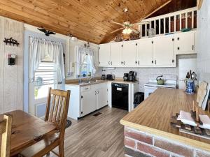 a kitchen with white cabinets and a wooden ceiling at Twin Sails Brought to you by GetAway Vacations in Wells +22 photos