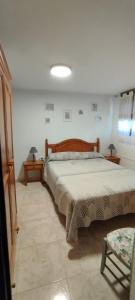 een slaapkamer met een groot bed en 2 tafels bij Casa katy in L'Escala