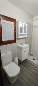 een witte badkamer met een toilet en een wastafel bij Casa katy in L'Escala