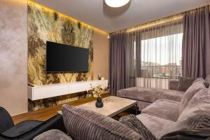 uma sala de estar com um sofá e uma televisão de ecrã plano em Central Victoria Home 2-bedroom apt em Plovdiv