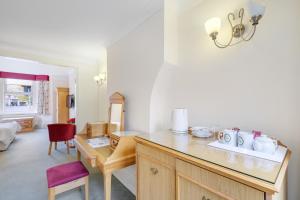 eine Küche mit einem Schreibtisch und einem roten Stuhl in der Unterkunft Charles House - Windsor Castle in Windsor