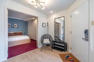 ein Schlafzimmer mit einem Bett, einem Spiegel und einem Stuhl in der Unterkunft Urban Nest, 1-BDRM Apt, Ground Floor in Halifax
