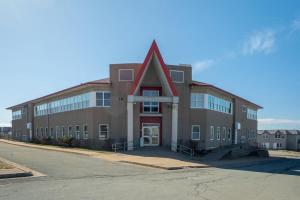 a large brick building with a red roof at Urban Nest, 1-BDRM Apt, Ground Floor in Halifax
