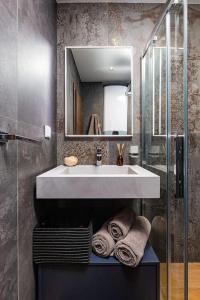 uma casa de banho com lavatório, espelho e toalhas em Central Victoria Home 2-bedroom apt em Plovdiv