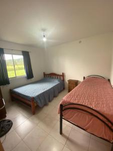 Schlafzimmer mit einem Bett und einem Fenster in der Unterkunft Complejo de Cabañas Ohana Salta in Campo Quijano