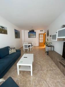 ein Wohnzimmer mit einem blauen Sofa und einem Tisch in der Unterkunft Apartamento Victor in Tossa de Mar