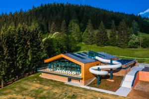 a building with a water slide in a field at Chata Pluskacka in Velké Karlovice
