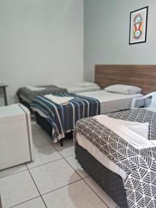 Habitación con 3 camas en una habitación en Hotel Araçariguama en Araçariguama