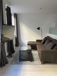 a living room with a couch and a flat screen tv at 2 BDRM Contemporary Central London Apartment in London