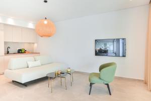 sala de estar con sofá blanco y silla verde en Acacia - Explore your senses en Preveza
