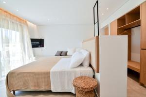 a bedroom with a large bed and a television at Acacia - Explore your senses in Preveza