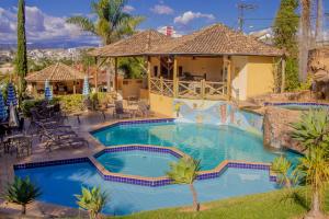 a swimming pool in a resort with a house at Vila Chico in São Lourenço