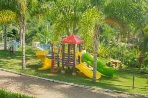 um parque com parque infantil com escorregas e árvores em Vila Chico em São Lourenço