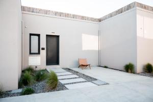 a white house with a bench in a courtyard at Acacia - Explore your senses in Preveza