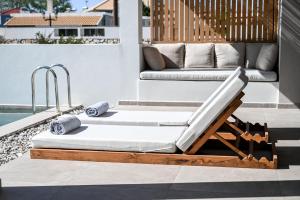 a lounging bed on a patio next to a pool at Acacia - Explore your senses in Preveza