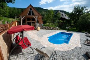 a red umbrella and chairs and a swimming pool at Chalet Stahl - Ferienhaus mit Pool in Freiburg im Breisgau
