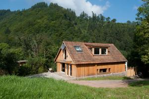 a wooden house in the middle of a field at Chalet Stahl - Ferienhaus mit Pool in Freiburg im Breisgau