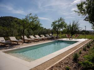 ein Pool mit Chaiselongue um ihn herum in der Unterkunft The Lodge Mallorca, Small Luxury Hotels in Sa Pobla