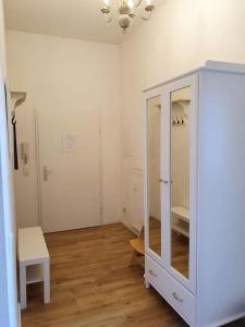 una camera con armadio bianco e pavimento in legno di 2 room apt. near station Neustadt in It district a Dresda