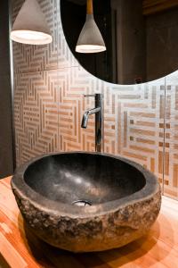 a bathroom with a stone sink and a mirror at Acacia - Explore your senses in Preveza