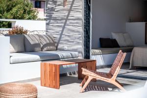 a patio with a chair and a table and a couch at Acacia - Explore your senses in Preveza