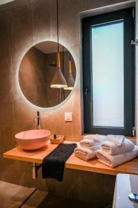a bathroom with a bowl sink and a mirror at Acacia - Explore your senses in Preveza